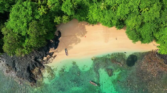 Aerial descending view from the Margarida beach with two boats anchored at turquoise sea at Ilha do Principe (prince Island) S&atilde;o Tom&eacute;, Africa