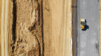 A road roller rams a gravel base during road construction top view. Road construction site. High quality photo