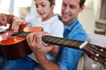 Guitar, hands or teaching with father and son on sofa in living room of home for music lesson....