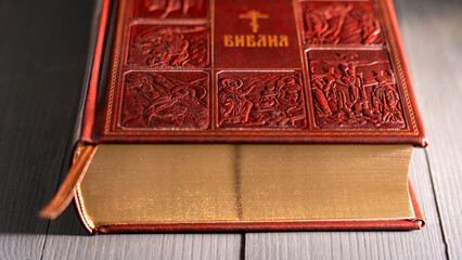 The Orthodox Bible. The Old and New Testaments. Wooden background. Close-up leather textured binding of the Orthodox Bible. Bible leather cover