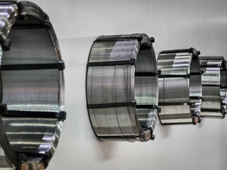 Coils of metal wire arranged on wall in workshop for manufacturing purposes