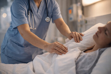 Infirmier prodiguant des soins &agrave; une patiente hospitalis&eacute;e