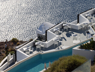 Naklejka premium Tables on the restaurant terrace with a picturesque view of the sunset in Imerovigli. Santorini, Greece.