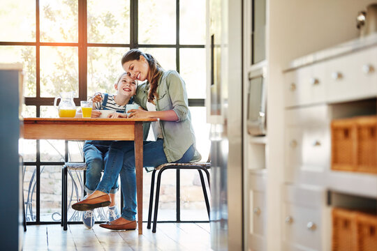 Breakfast, mother and hug child for love, care and connection with daughter in home kitchen. Morning food, mama and girl embrace with parent for support, smile and family bonding together with trust