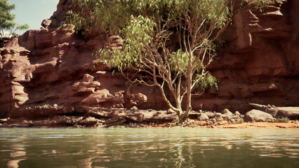 Calm waters ripple gently along the shore, reflecting the striking cliffs and a lone tree. The scene captures the beauty of nature in a serene landscape, inviting relaxation.