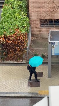 Andando bajo la lluvia con paraguas en d&iacute;a de agua, precipitaci&oacute;n y tormenta