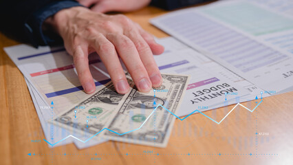 Hand showing dollar note with monthly budget planning, budget allocation for business or project management. Effective and smart budgeting