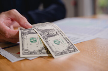 Hand showing dollar note in concept of budget planning paying and financial investment, budget allocation for business or project management. Effective and smart budgeting.