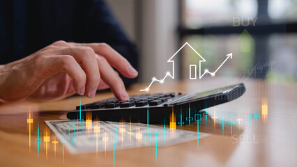 Businessman hand using calculator calculating prices and interests in Real estate investment...
