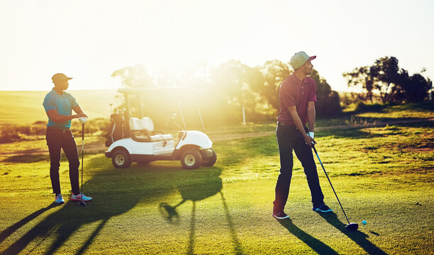 Golf, personal trainer and shot with hobby, game and weekend for practice with bonding together. Men, people and swing with sport club, golfing course and sunshine outdoor with equipment and flare - Powered by Adobe