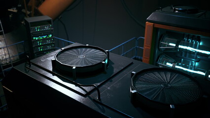 Two circular fans sit on a glossy surface in a dimly lit industrial setting. Surrounding machinery glows softly, creating a futuristic atmosphere with dark tones and vibrant highlights.