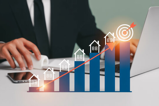Businessman reviewing real estate investment growth with upward trend line and target chart graph