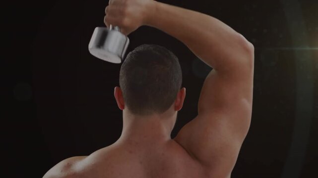 Male extending elbow, doing fitness triceps extension with chrome dumbbell, black backdrop, flare