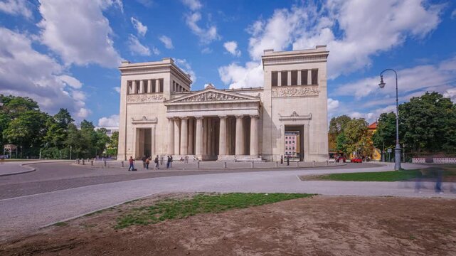 Hyperlapse timelapse footage of Munich featuring the Propylaea monument at K&ouml;nigsplatz, Germany. The historic landmark stands at the heart of the Munich cityscape while dynamic camera movement creates