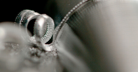 MACRO: Sharp cutter cuts into steel cylinder as it is being processed into bolt.