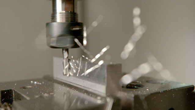 MACRO: Aluminium shavings come flying off a small workpiece during end milling.