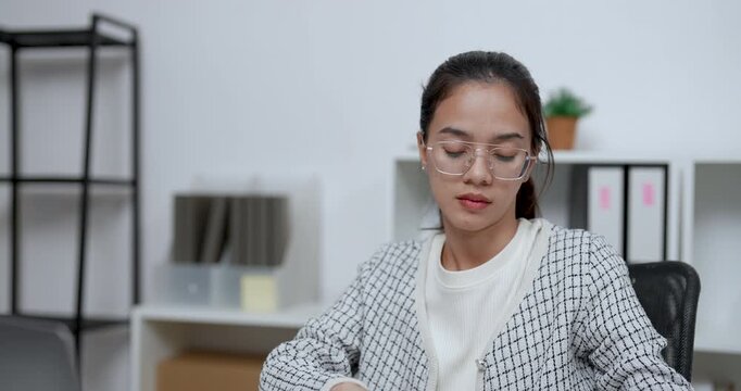 asian businesswoman sitting at home office calmly reading book with thoughtful expression gaining inspiration for career planning learning and self development