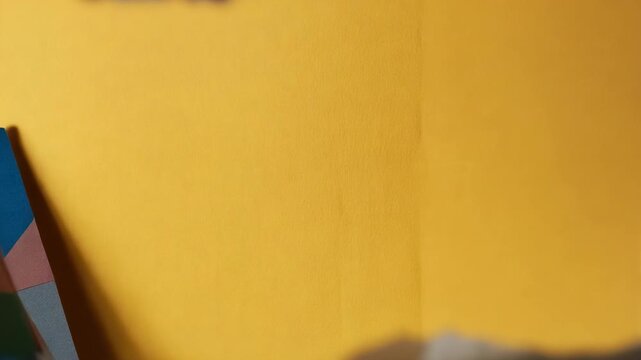 Zooming camera moving closer through torn paper stack on tabletop, revealing blue green yellow