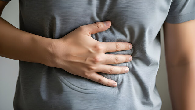 Stomach ache. Image of an adult man holding his stomach. Concept of constipation, diarrhea, digestive disorders. Concept of health and medical photos.