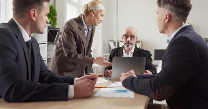 Business meeting team planning strategy in office. A leader guides colleagues at a laptop with charts, driving discussion and key presentation. Clear concept of teamwork and leadership.