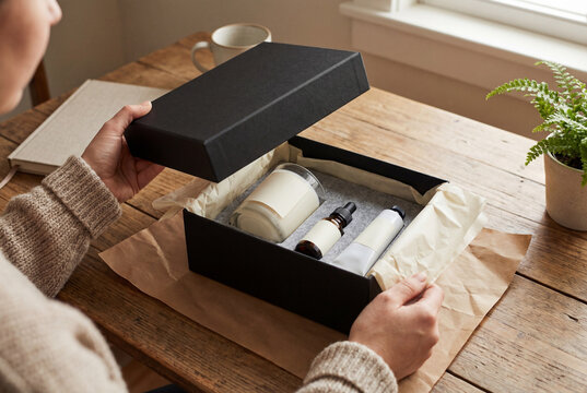 Woman unboxing luxury self-care set at home