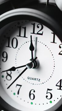 Time ticking on old fashioned alarm clock with bells. Charming black clock ticks steadily, marking every second with grace. Time concept. Clock running fast. Close-up in 4K, UHD