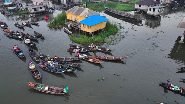 Aerial view of boats navigating the waterways and stilt houses, creating a vibrant scene of life on water, Ganvie, Atlantique Department, Benin.