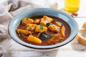 Cod with potatoes on white wooden table.Traditional Spanish dish