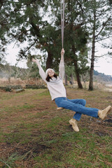 Swing, girl, outdoors, park, a playful, carefree moment with smiling youth in casual attire, surrounded by trees and grass, laughter, sunlight, capturing nature and joy