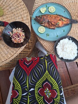 A table laid with a meal of fish, coconut rice, and salad