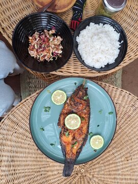 A table laid with a meal of fish, coconut rice, and salad