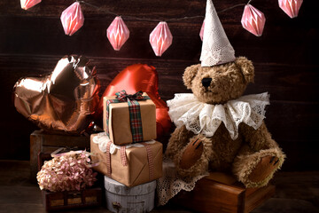 Vintage style teddy bear in lace ruff collar and a cap at a birthday party
