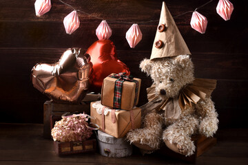 Vintage style teddy bear in paper ruff collar and a cap at a birthday party