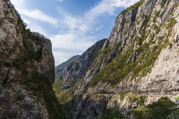 Naklejka premium A dramatic mountain gorge features towering rocky cliffs