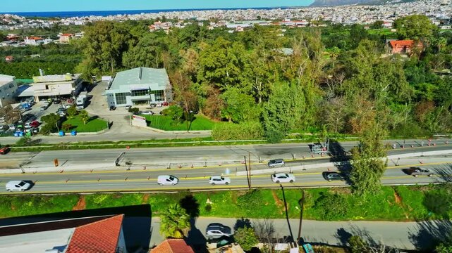 Aerial view of buildings, road, cars and trees, following a car as it enters the deviation due to road works, Chania, Chania, Greece.