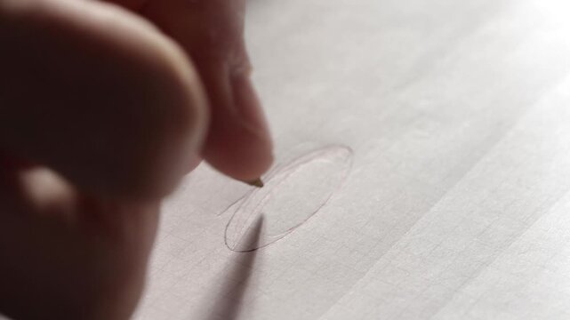 Hand sketching a light pencil outline of an oval shape on paper