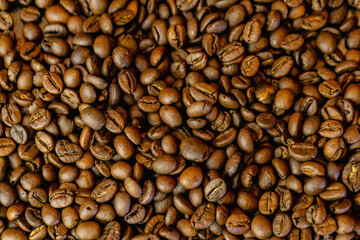Fototapeta premium Coffee beans background with rich brown tones and natural texture. Roasted coffee beans close-up, creating a warm and aromatic backdrop ideal for coffee shops, cafes, menus, packaging, branding, food 
