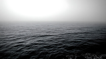 Obraz premium Dark ocean waves stretch toward a dense white fog on a mysterious and silent horizon, captured in a minimalist, high-contrast monochromatic style.