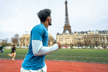 Athlete running on track with eiffel tower background in paris
