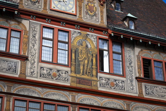 View of ornate frescoes adorn the historic facade, a clock tower watches over the scene in Tubingen, Baden-Wurttemberg, Germany.