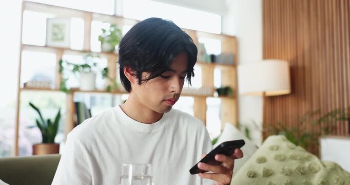Man, phone and drinking water on couch with texting, relax and home with web chat in living room. Person, smartphone and glass for hydration on sofa, mobile app or scroll on social network at house