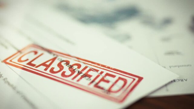 Red secrecy stamp prominently marks classified documents on table, alongside paper map of world, underscoring global security classification, secrecy, and sensitive information in sensitive context