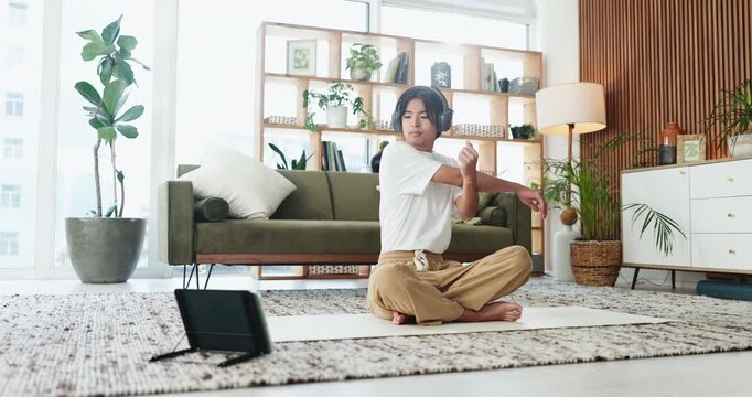 Man, stretching and headphones with tablet for online tutorial, exercise or yoga course in home. Male person, yogi or streaming with technology or warm up for virtual guide, health or wellness tips