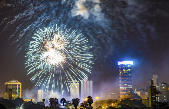 View of vibrant fireworks exploding over the city skyline, illuminating the dark sky above the buildings and trees, Nairobi, Nairobi, Kenya.