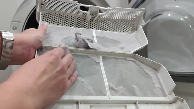 Woman is cleaning filter of drying machine 
