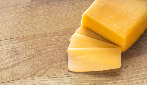 piece of cheese close-up on a wooden kitchen board