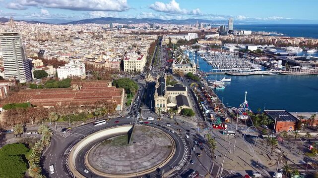 Aerial view of Port Vell area in Barcelona, showing the Plaza de les Drassanes roundabout, the Columbus Monument, and the waterfront with the marina, Spain