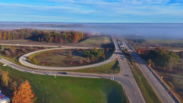 Highway I-96 exit in Lake Odessa, Michigan, USA with autumn colors and morning fog