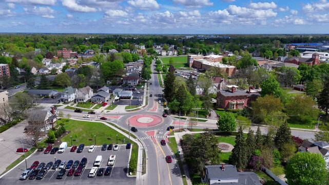 Aerial view of a busy traffic roundabout in Adrian, Michigan, USA surrounded by buildings and trees