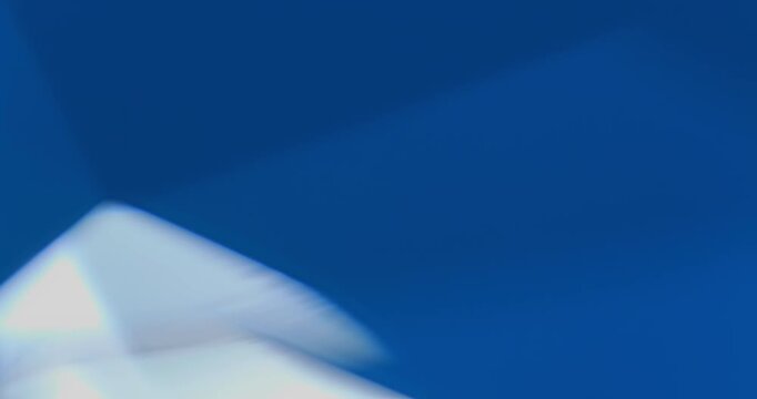 Abstract background with light effects. Dynamic interplay of vibrant blue triangular facets with shifting glows and reflections in motion.